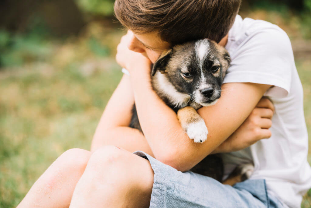 child hugging a dog 