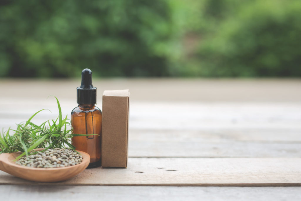 Cannabis, Cannabis seeds, Cannabis oil Placed on a wooden floor With a green tree background in the background.